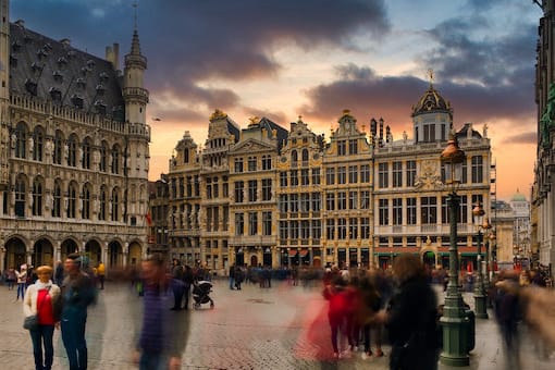 a group of people walking around a city square.