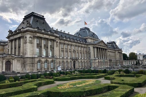 un grand bâtiment avec un jardin devant. a large building with a garden in front of it.